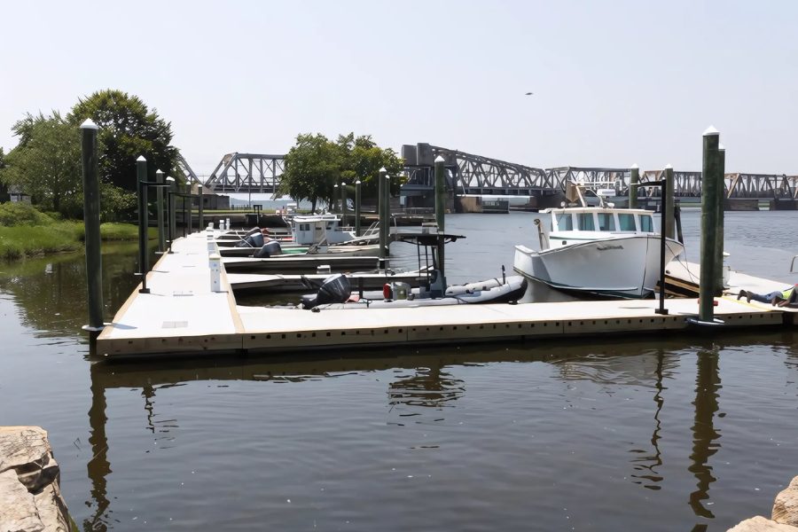 New floating docks at the DEEP Marine Headquarters marina with boats berthed and the railroad bridge behind