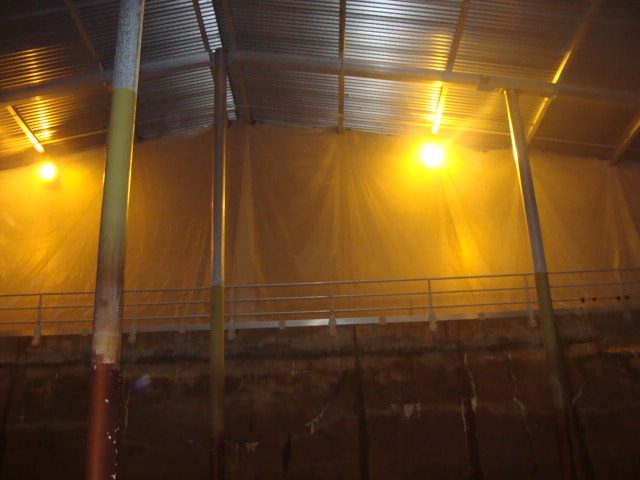 Lit basin interior with protective sheeting hung along the walls