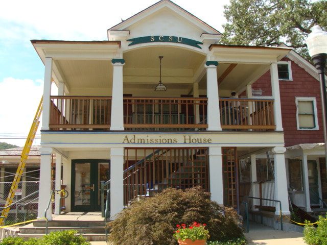 Admissions House two-story porch with restored columns and wood railings