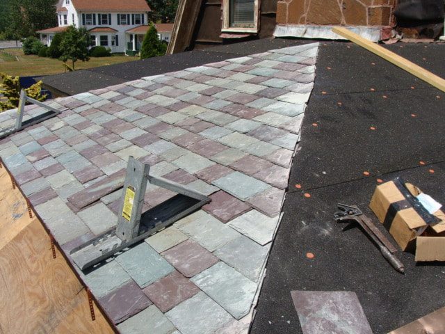New multi-color slate being laid over underlayment